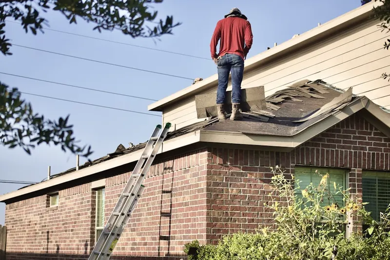 Professional roofer working on a residential roof in Woodmont